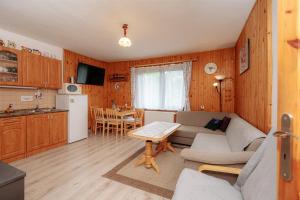 a kitchen and a living room with a couch and a table at Chalúpka Lavender in Zázrivá