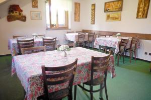 a dining room with tables and chairs with flowers on them at Pension Sport Ostružná in Ostružná