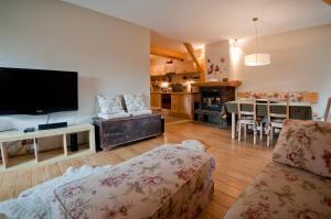 a living room with a flat screen tv and a couch at Apartments Zakopane Center in Zakopane