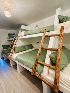 a bedroom with two bunk beds with green pillows at The Hideout Samui in Koh Samui 
