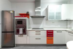 uma cozinha com armários brancos e um frigorífico de aço inoxidável em Coqueto y Tranquilo en el Centro em Bilbau