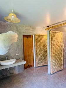 un bagno con lavandino e 2 porte in legno di The Hideout Samui a Ko Samui