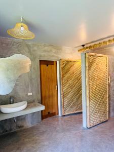 a bathroom with a sink and two wooden doors at The Hideout Samui in Mae Nam +9 photos
