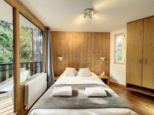 夏慕尼白朗峰的住宿－Le Caribou，一间卧室设有一张大床和一个大窗户