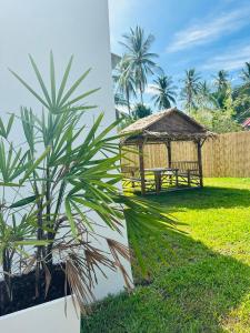 a bench and a gazebo in a yard at The Hideout Samui in Mae Nam