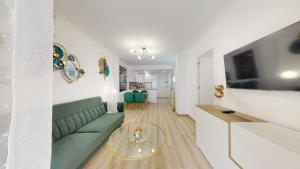 Pedro Lorca في توريفايجا: غرفة معيشة مع أريكة خضراء وطاولة زجاجية