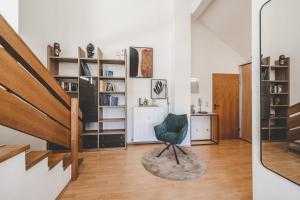 a living room with a green chair and a staircase at Vitaloase Bad Griesbach im Rottal/70qm/Auszeit/Parkplatz in Bad Griesbach