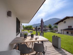 a wooden table and chairs on a patio with a yard at Das Karl Appartement in Söll