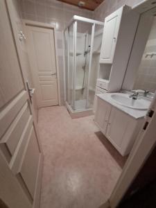biała łazienka z umywalką i prysznicem w obiekcie appartement 3 chambres w mieście Cauterets