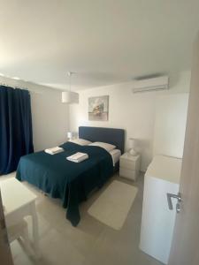 een slaapkamer met een bed met een blauwe deken bij Apartmant Sea View in Poljica