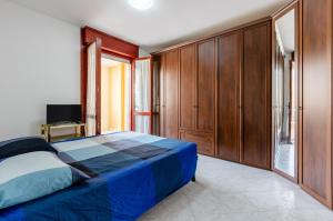 um quarto com uma cama azul e armários de madeira em Quartu Sant'Elena - Roomy Apartment with Parking! em Su Forti