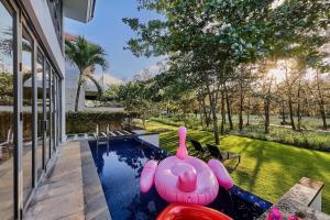 a swimming pool with a pink inflatable pig in a yard at Ocean Beach Villas Danang in Da Nang
