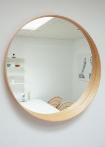 a mirror on a wall with a table and two chairs at Strandhotel SüdSee Diessen am Ammersee in Dießen am Ammersee