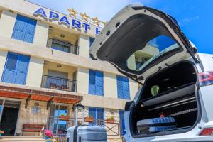 a car with its trunk open in front of a hotel at Apart hotel M S KATUNJANIN in Herceg-Novi