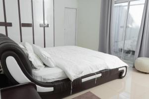 1 cama con sábanas blancas y almohadas en una habitación en Miyaheli Inn en Hithadhoo