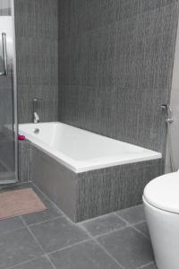 a bath tub in a bathroom next to a toilet at Miyaheli Inn in Hithadhoo