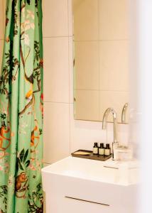 a bathroom with a sink and a shower curtain at Strandhotel SüdSee Diessen am Ammersee in Dießen am Ammersee