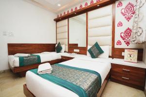 sypialnia z 2 łóżkami i lustrem w obiekcie Hotel Kabir Palace Karol Bagh w Nowym Delhi