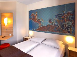 - une chambre avec un lit orné d'une peinture murale dans l'établissement B&B HOTEL Magdeburg-City, à Magdebourg