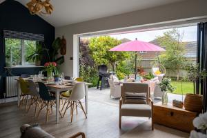 een eetkamer met een tafel met een roze paraplu bij Cliff House in Lymington