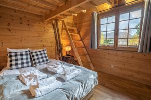 a bedroom with a bed in a log cabin at Chalet Luxe Les Orchis Alpe d'Huez in LʼHuez