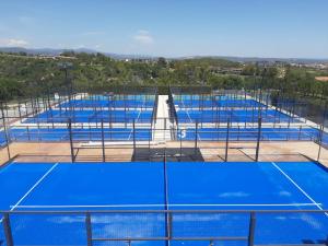 a row of blue tennis courts on a tennis court at CoolTainer retreat: Sustainable Coastal forest Tiny house near Barcelona in Castelldefels