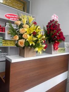 dos ramos de flores en un mostrador en una tienda en Ánh Mai Hotel, en Bao Loc