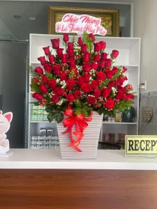 un gran ramo de rosas rojas en un mostrador en Ánh Mai Hotel, en Bao Loc