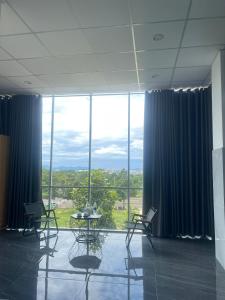 a room with a table and chairs and a large window at Ánh Mai Hotel in Bảo Lộc