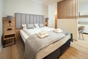 1 dormitorio con 1 cama grande y toallas. en Symphony City Square Aparthotel, en Wroclaw