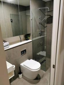a bathroom with a toilet and a glass shower at Urban Oasis: Central Wollongong in Wollongong