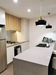 a kitchen with a white counter top in a room at Urban Oasis: Central Wollongong in Wollongong
