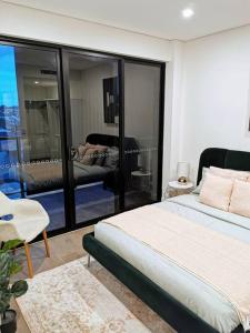 a bedroom with a large bed and a balcony at Urban Oasis: Central Wollongong in Wollongong