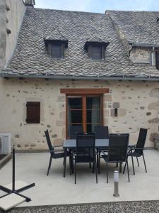 une table et des chaises devant un bâtiment dans l'établissement Les copains d'abord, à Argentat