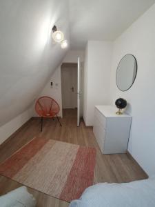 1 dormitorio con cama, espejo y silla en " Les copains d'abord ", en Argentat