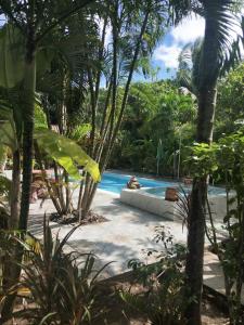 - une piscine dans un complexe avec des palmiers dans l'établissement Ban Elephant Blanc Bungalow, à Kata Beach
