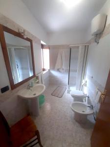 ein Badezimmer mit zwei Waschbecken, einem WC und einem Spiegel in der Unterkunft RESIDENZA RURALE L'ANTICO CASTAGNETO in Sicignano degli Alburni