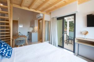 a bedroom with a bed and a kitchen with a balcony at Zisis Suites in Nydri