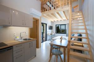 una cucina e un soggiorno con scala in una casetta minuscola di Zisis Suites a Nydri