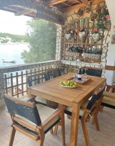 una mesa de madera y sillas con un plato de fruta. en Holiday Home Jelena, en Zastražišće