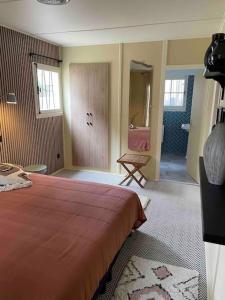a bedroom with a large bed and a bathroom at Cottage de la Risle in Pont-Audemer