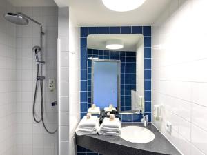 a bathroom with a sink and a shower at B&B Hotel Hamburg-Nord in Hamburg