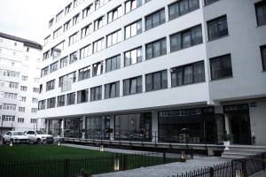 a large white building with cars parked in front of it at NORDIC Residence 46 in Suceava