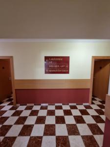 a room with a checkered floor and a sign on the wall at Zöldsziget Menedék, Rendezvény-és pihenőház in Bárna