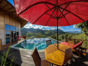a patio with a table and an umbrella and a pool at Villa Russerangan Grand Opening in Praya