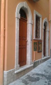 Casa Antico Borgo Cuseni في تاورمينا: مبنى عليه باب خشبي
