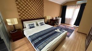 a bedroom with a large bed and a window at Tian-Shan Hotel in Bishkek