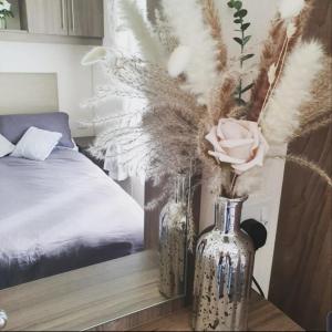 a couple of vases with feathers in a bedroom at Kjs holiday home in Saint Osyth
