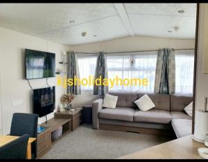 a living room with a couch and a tv at Kjs holiday home in Saint Osyth