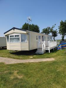a mobile home is parked in a field at Kjs holiday home in Saint Osyth